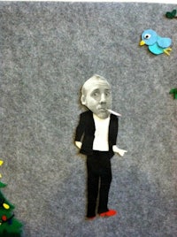a paper cut out of a man in a suit and a bird