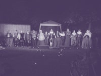 a group of people dressed in renaissance costumes stand on a stage