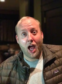 a man in a jacket is making a funny face