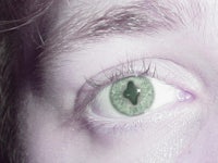 a close up of a person's eye with green eyes
